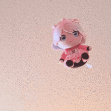 a pink and white stuffed animal is sitting on a wall