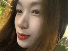 a close up of a woman 's face with red lipstick on