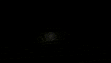 a group of people are standing in a dark room with a light coming out of it .