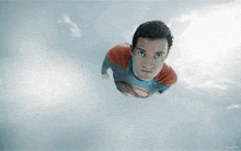 a man in a superman costume is flying through the sky