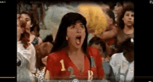 a woman in a red shirt with the numbers 1 and 2 on it