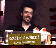 a man behind a sign that says " golden wheel "