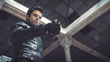 a man in a leather jacket is holding a knife in his hand
