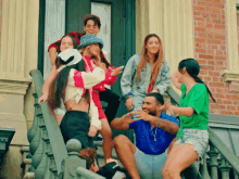 a group of people are sitting on a set of stairs in front of a brick building