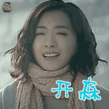 a woman wearing a scarf and a sweater is smiling with chinese characters above her head