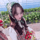a girl wearing a head scarf is picking strawberries