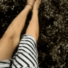 a person is laying on the ground with their legs crossed and their feet up .