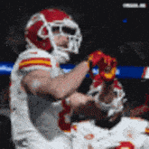 a football player wearing a helmet and gloves is standing on the field .