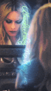 a woman looking at herself in a mirror with the words " charlize theron " written in neon
