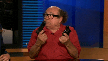 a man in a red shirt is holding two guns