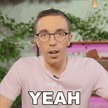 a man wearing glasses and a pink shirt is saying " yeah "