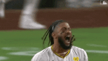 a man is screaming on a baseball field while wearing a jersey with the number 95 on it .