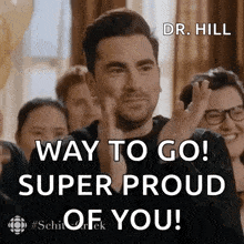 a man is applauding in front of a group of people with the words way to go super proud of you .