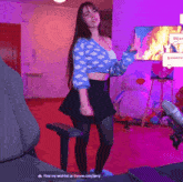 a woman is dancing in front of a screen that says " find my wishlist at throne.com/enz "