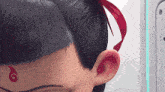 a close up of a person 's ear and hair with a red g on the forehead