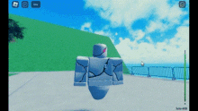 a video game character is flying in the air in front of a body of water .