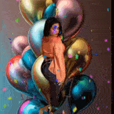 a woman is standing in front of a bunch of balloons with the word love written on one of them