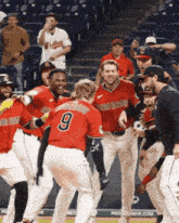 a group of baseball players with one wearing a number 9 jersey