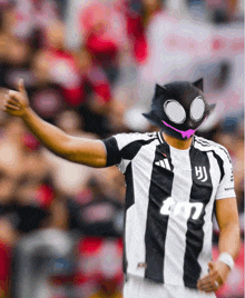 a soccer player wearing a cat mask and a juventus jersey gives a thumbs up