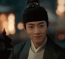 a man with a bun on his head is wearing a hat