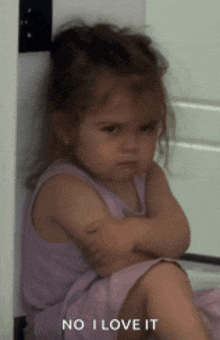 a little girl with her arms crossed and the words no i love it behind her