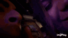 a close up of a person 's face with a purple light behind them .