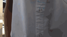 a close up of a person wearing a white shirt with buttons on the sleeves