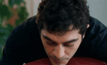 a close up of a man 's face while eating a piece of pizza .