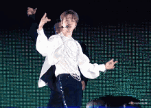 a man in a white shirt is dancing in front of a green background