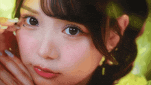 a close up of a woman 's face with her hand on her cheek