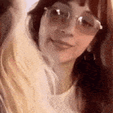 a woman wearing sunglasses and a white shirt is smiling .