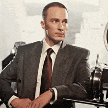 a man in a suit and tie is adjusting his jacket .