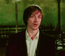 a man with a surprised look on his face is wearing a suit