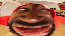 a man with a beard is wearing a red hat and making a funny face
