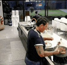 a woman cooking in a kitchen with a sign that says go in the background