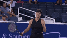 a woman holding a tennis racquet in front of a banner that says southern