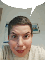 a woman making a funny face with a speech bubble above her head and a calendar on the wall behind her that says april