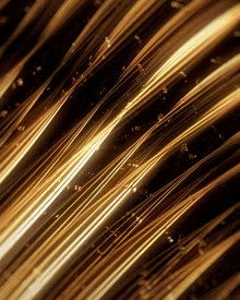 a close up of a gold colored surface with a dark background