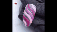 a close up of a nail with a pink and silver swirl design on it .