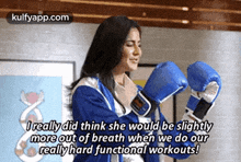 a woman wearing blue boxing gloves is talking about her workouts .
