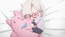 a little girl with glasses is laying on a bed with a pink pillow