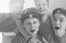 a group of men are posing for a picture together and laughing .