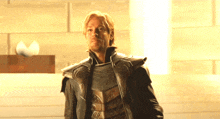 a man in armor stands in a dark room