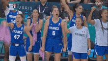 a group of female basketball players from france are cheering