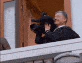 a man in a suit and tie is holding a camera and smiling