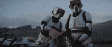 two stormtroopers are standing next to each other in a field