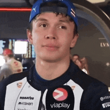 a young man wearing a blue hat is talking into a microphone with the word viaplay on it