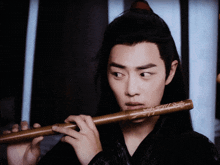 a man playing a flute with chinese writing on it
