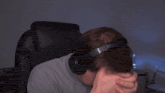 a man wearing headphones is covering his face with his hand and the word axuetb is written above him