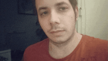 a man wearing a red shirt with the letter r on it